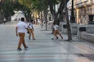 Children play some soccer along the Prado in the early morning