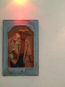 a Trinidad artist carves soulful locals on panels of wood.